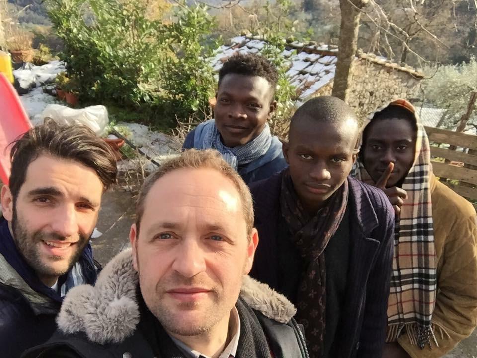 In un paese imbiancato dalla neve, il parroco di Marliana don Alessandro Carmignani con alcuni profughi