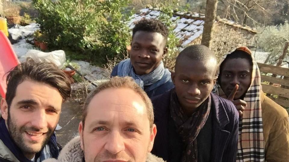 In un paese imbiancato dalla neve, il parroco di Marliana don Alessandro Carmignani con alcuni profughi