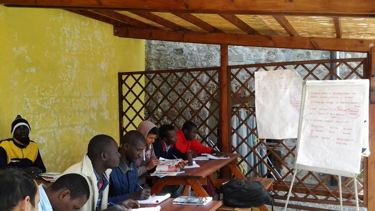 Stranieri a lezione di italiano in una struttura di accoglienza a Lucca