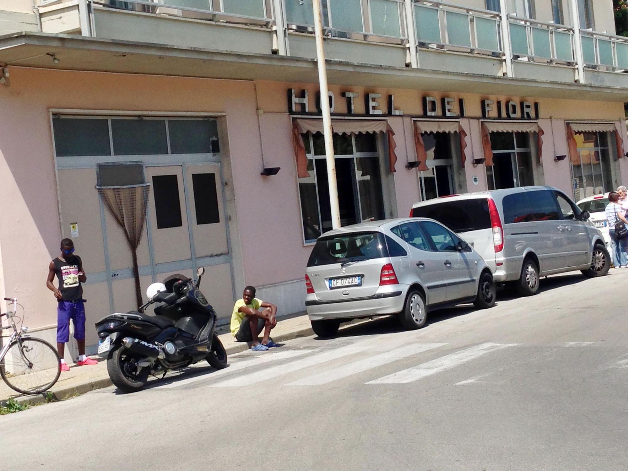 Alcuni migranti davanti all'hotel dei Fiori a Pescia