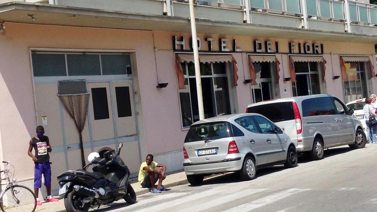 Alcuni migranti davanti all'hotel dei Fiori a Pescia