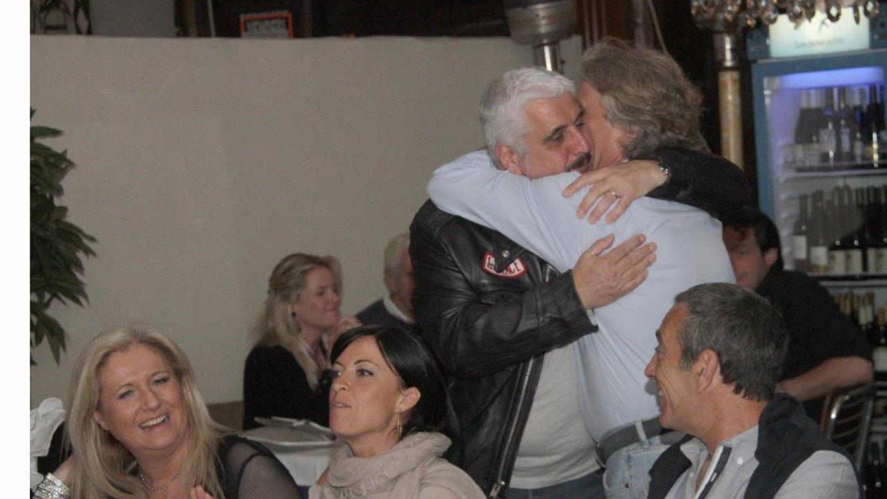 Pino Daniele abbraccia Giancarlo Ciarpi, direttore della Banca della Maremma, per il suo compleanno nel 2012 al ristorante Il Cartello di Paolo Fantoni ad Ansedonia (foto Enzo Russo)