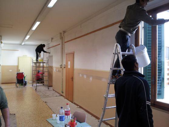 I rifugiati mentre imbiancano la scuola di Poggio a Caiano