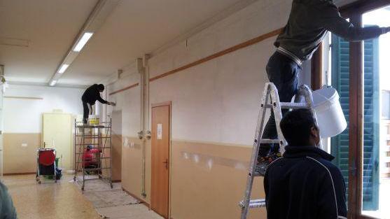 I rifugiati mentre imbiancano la scuola di Poggio a Caiano