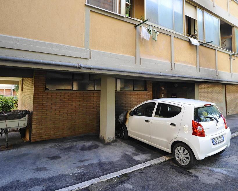 Una delle auto incendiate sotto i portici a Barbanella