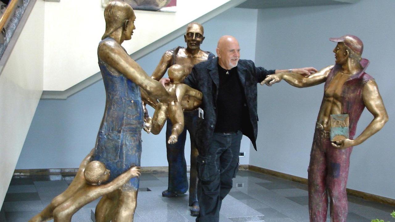 Guglielmo Malato al centro di una sua scultura in bronzo