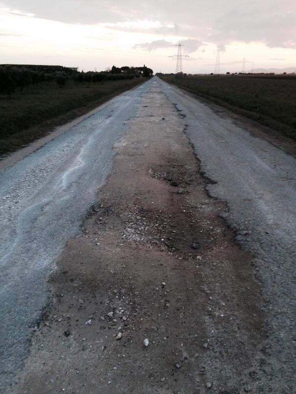 La strada di Bandita, con poco asfalto e molte buche 
