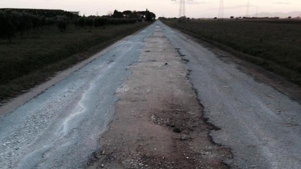 La strada di Bandita, con poco asfalto e molte buche