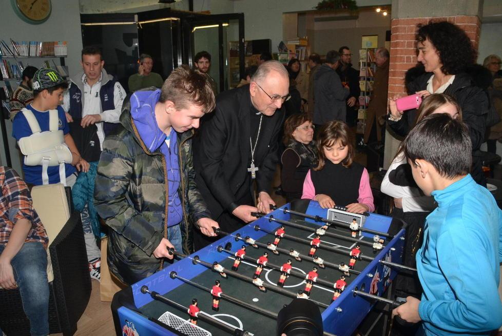 Il vescovo gioca a biliardino contro le slot machine 