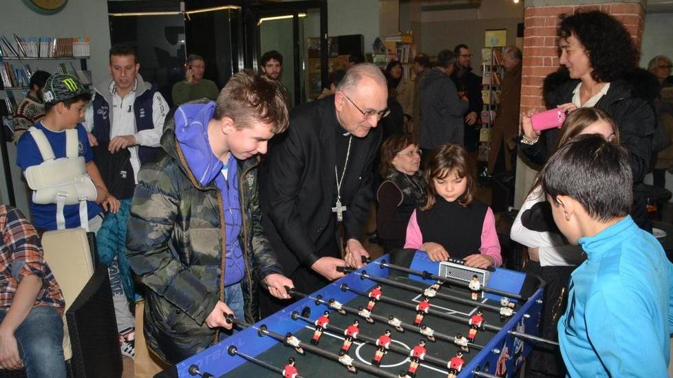 Il vescovo gioca a biliardino contro le slot machine