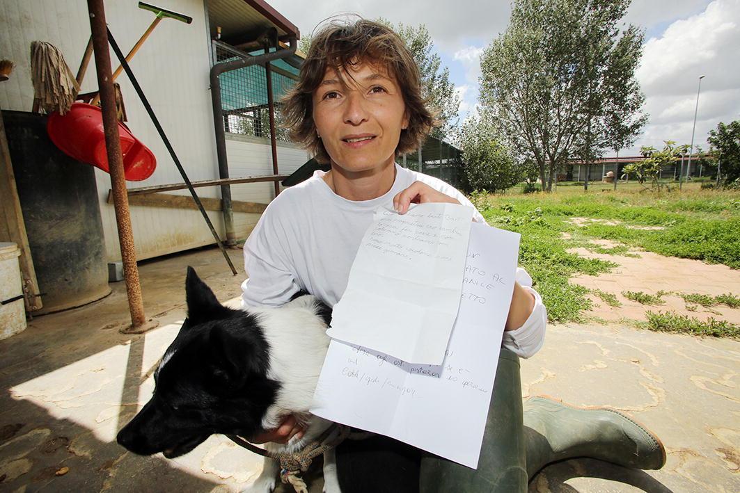 Il cane Bart con una volontaria e con il foglio con cui venne trovato 