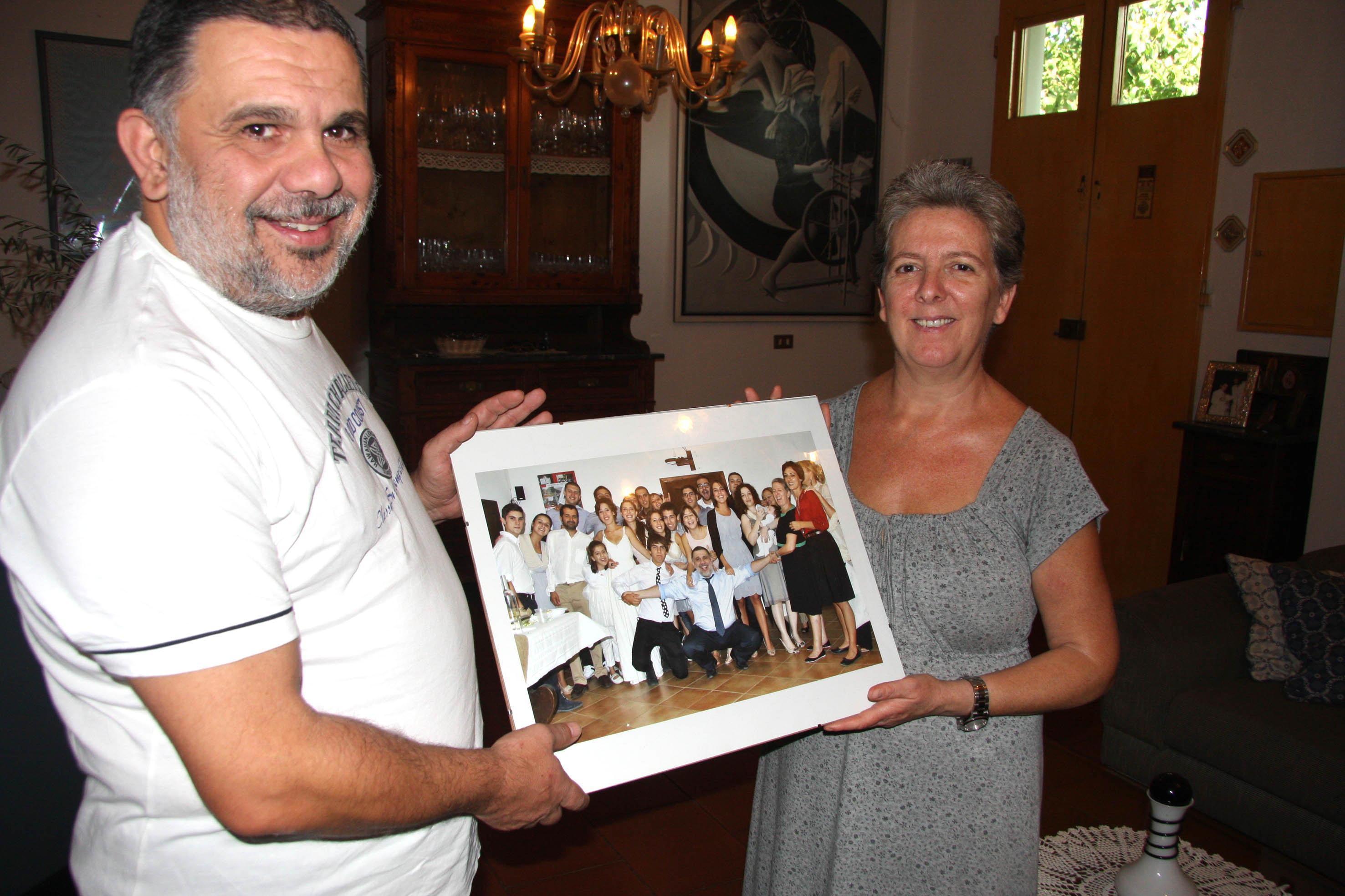 Luca e Annamaria Leoni mostrano la foto della loro famiglia numerosa