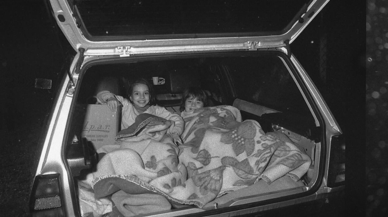 Una delle foto simbolo: una famiglia dorme nel bagagliaio di un'auto (Foto Vip)