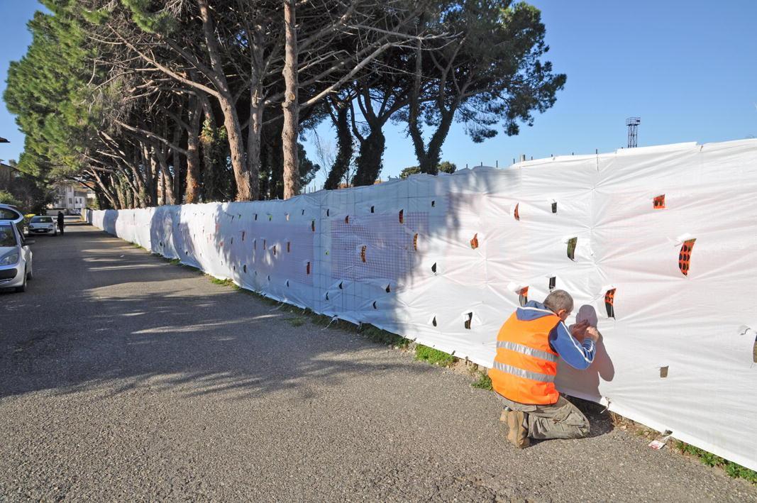 L'operaio dell'ex zuccherificio mentre sistema il telo in via della Pinetina