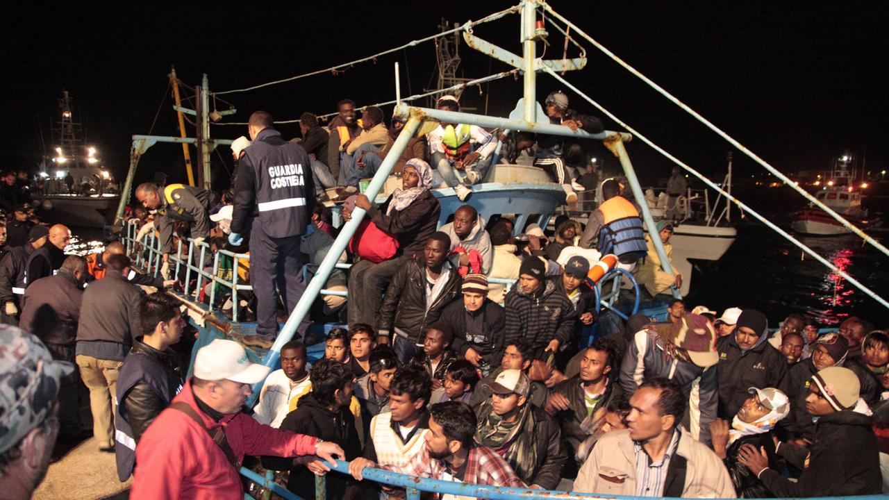 Un barcone con immigrati soccorso lungo le coste italiane (foto Ansa)
