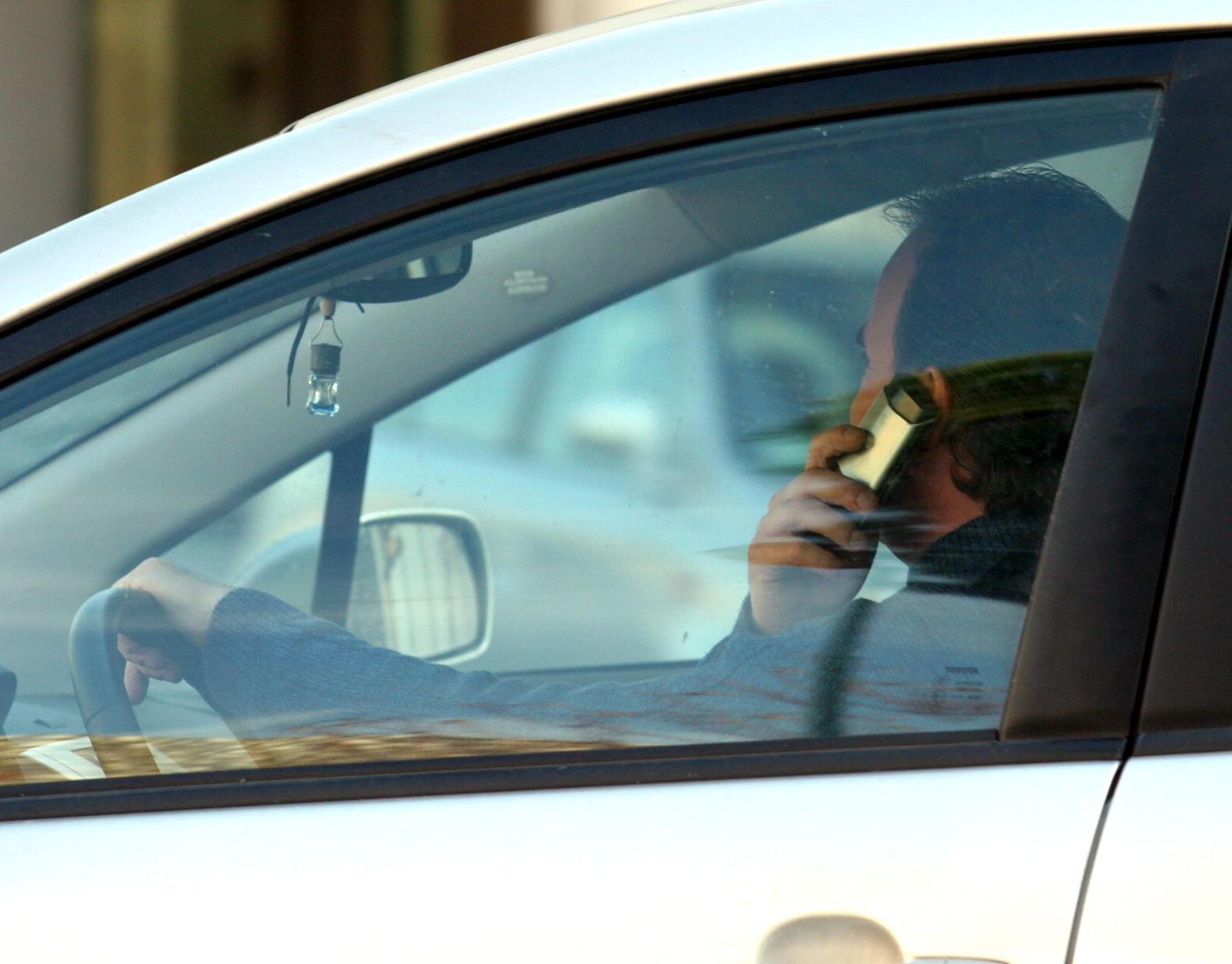 Un automobilista al cellulare mentre guida