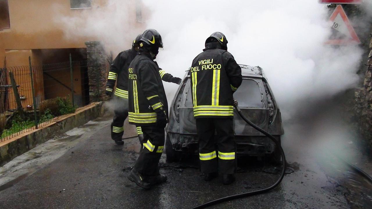 I pompieri al lavoro per spegnere l'auto andata a fuoco
