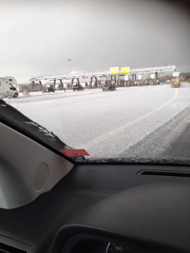 Carreggiata ricoperta di grandine al casello autostradale di Vada