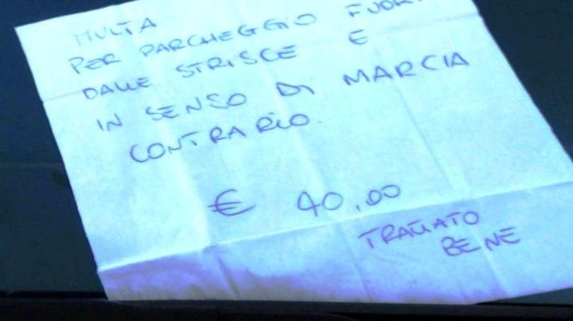 Il foglietto di carta sotto il tergivetro è l'ironica "multa" del cittadino ai vigili