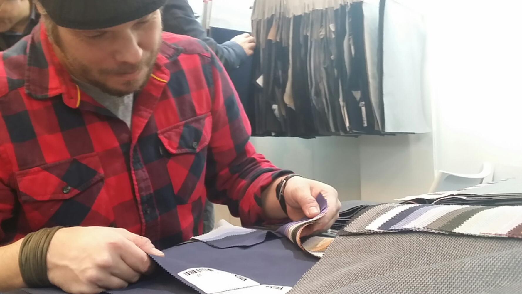Uno stilista sceglie i tessuti nello stand di un'azienda pratese