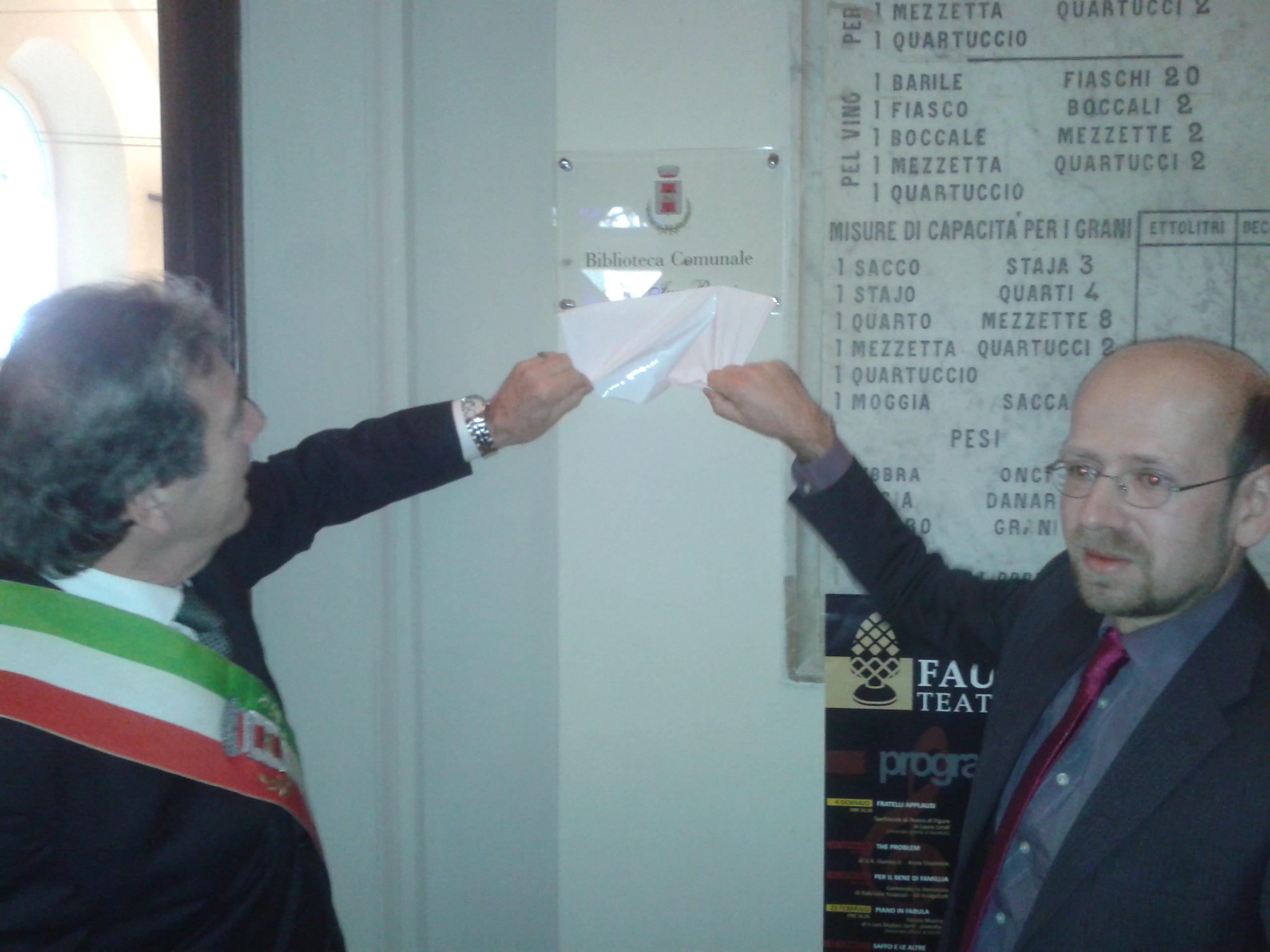 Il sindaco Carlo Carli e Michele Bacci, figlio dell'ex primo cittadino Ivo Bacci scoprono la targa della nuova biblioteca