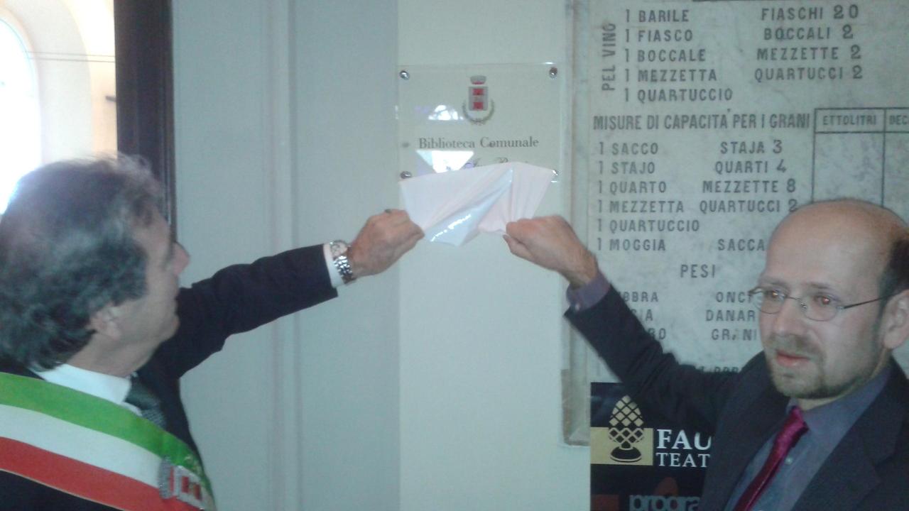 Il sindaco Carlo Carli e Michele Bacci, figlio dell'ex primo cittadino Ivo Bacci scoprono la targa della nuova biblioteca
