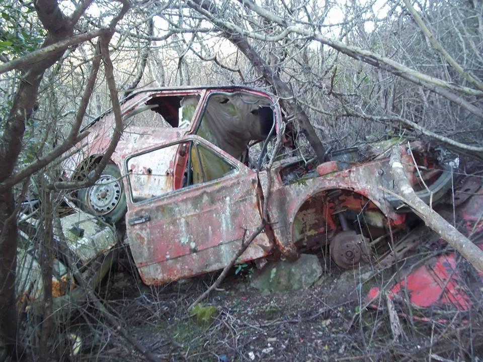 Carcasse di un'auto lungo il sentiero