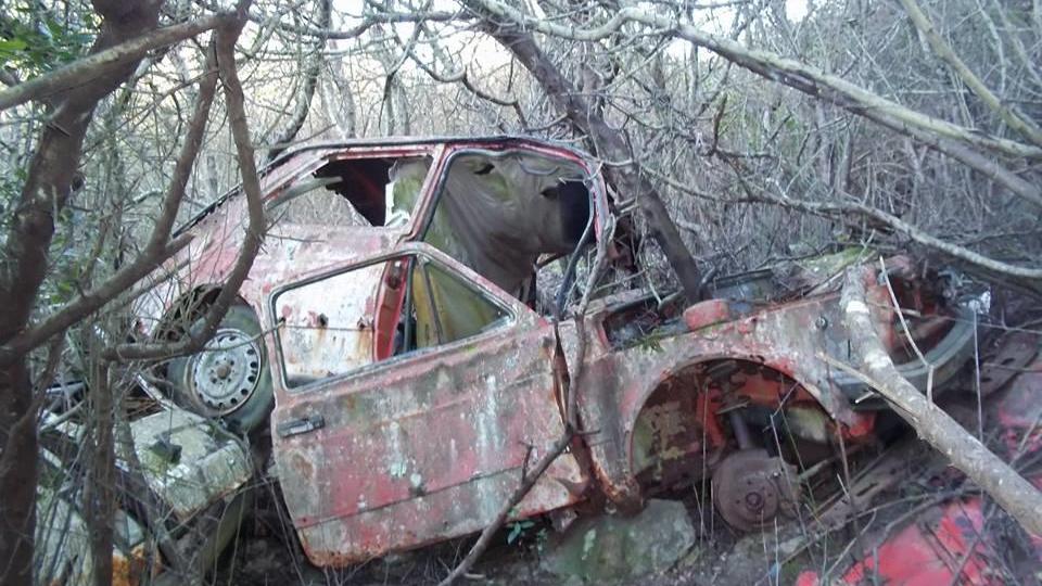 Carcasse di un'auto lungo il sentiero