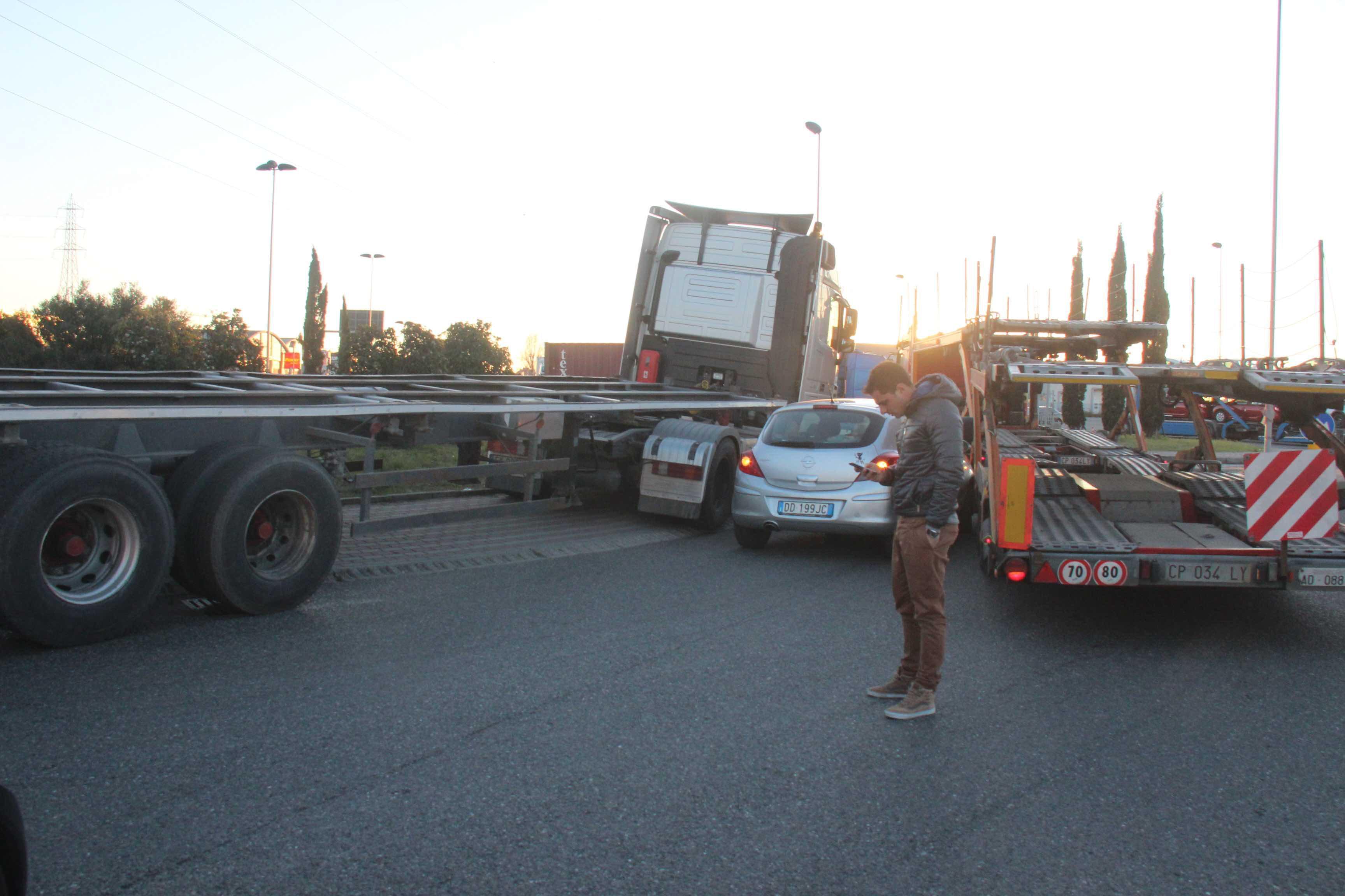 L'auto e la bisarca ferme e un tir che sale sulla rotatoria per passare (Foto Vincenzoni)