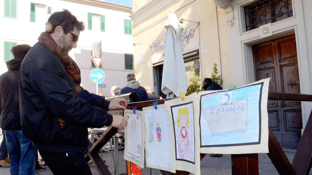 Angelo Taravella con i disegni dei bambini dedicati a Dayana, fuori dal teatro Moderno (foto Bf)