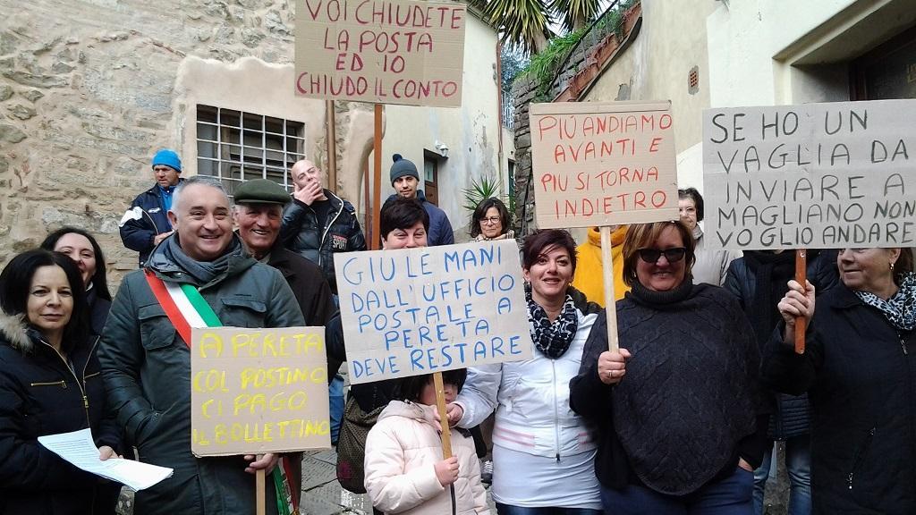 Sindaco e abitanti di Pereta mostrano i cartelli contro la chiusura dell'ufficio postale