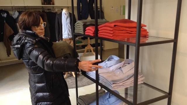 La titolare del negozio mostra lo scaffale depredato