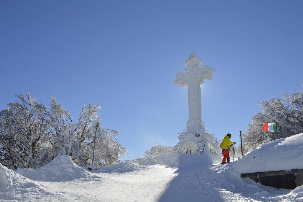 La croce innevata sulla vetta della montagna