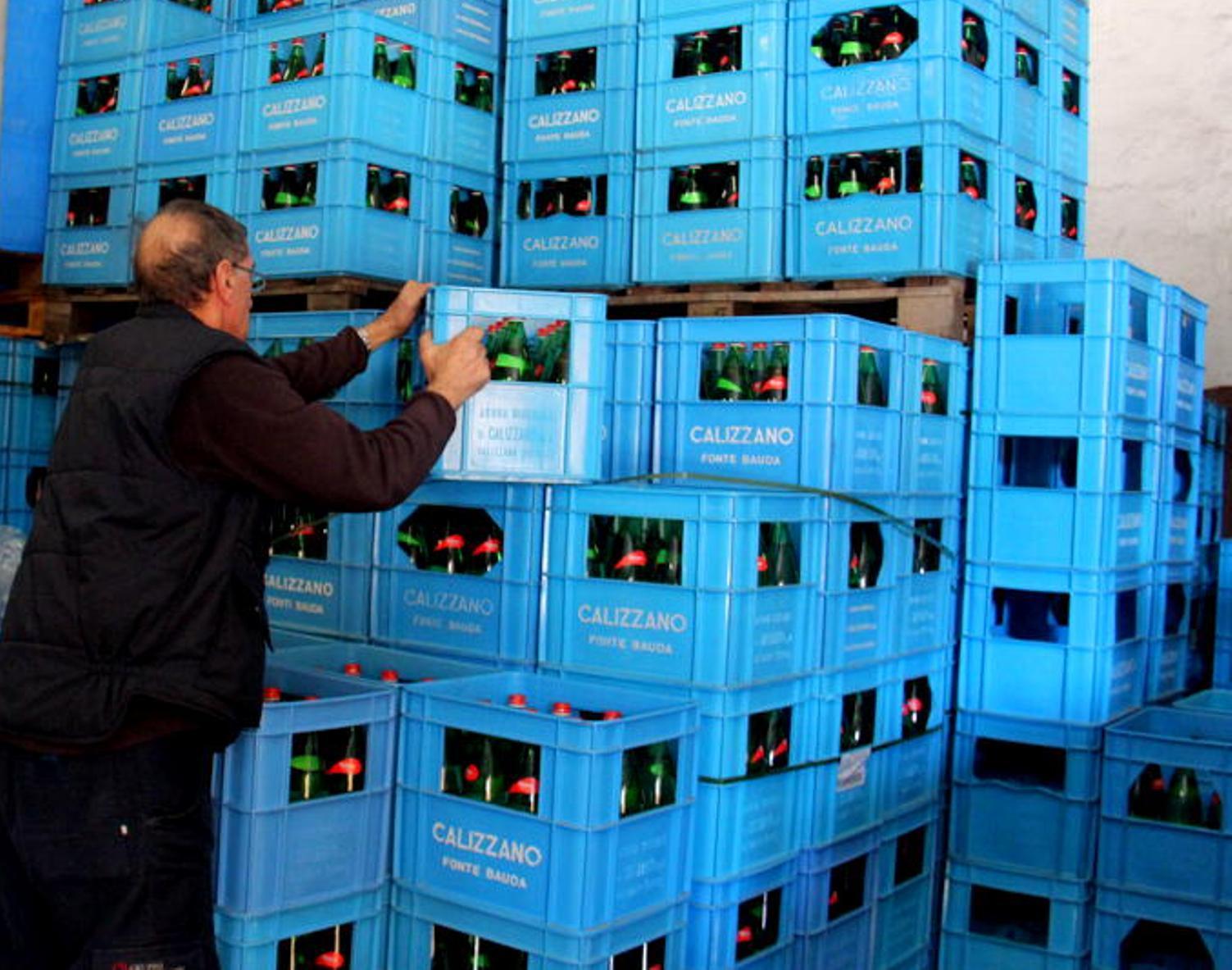 Uno dei due soci della società Amba al lavoro fra le casse di bottiglie di acqua (Marzi Pentafoto)
