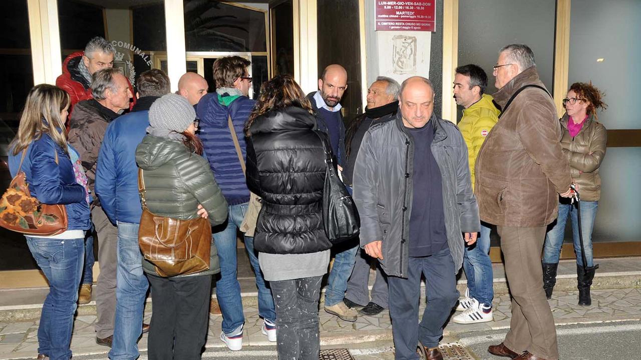 La scientifica e il medico legale escono dall'obitorio dopo aver concluso l'autopsia, tra una piccola folla di amici (foto Paolo Barlettani)