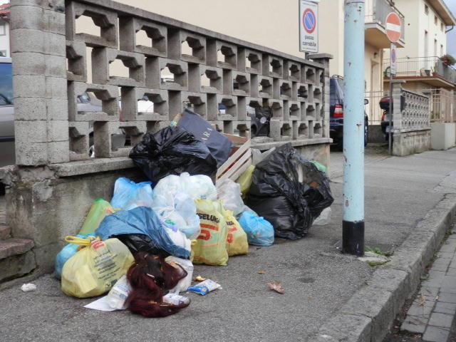 Sacchi dell'immondizia accastatati sul marciapiede in via Barsanti