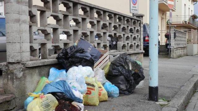Sacchi dell'immondizia accastatati sul marciapiede in via Barsanti