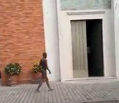 Il giovane completamente nudo all'ingresso della chiesa