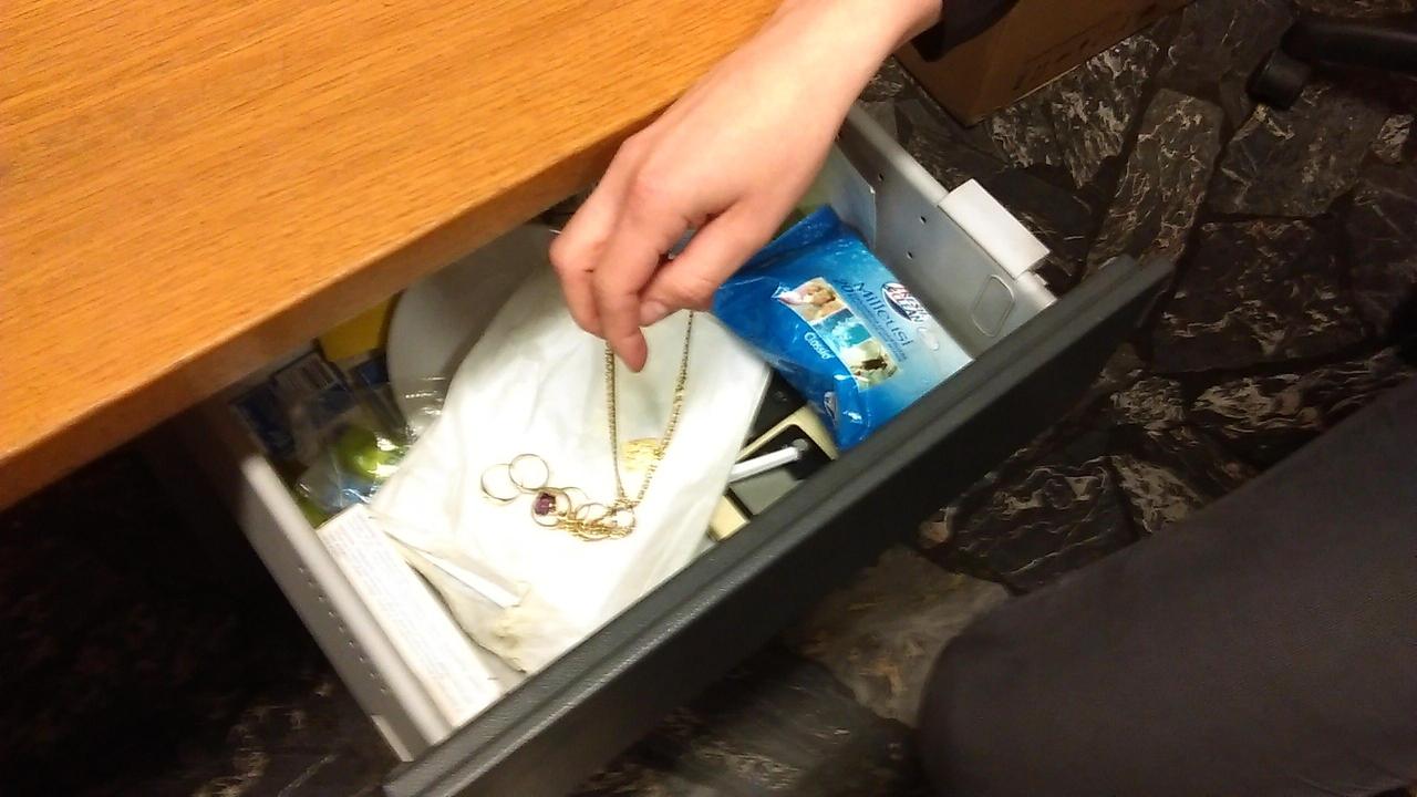 Una donna ruba da un cassetto