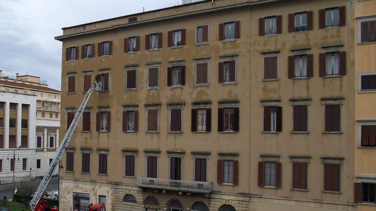 L'autoscala dei pompieri al lavoro per una persiana pericolante sugli scali del Corso, dietro al Comune
