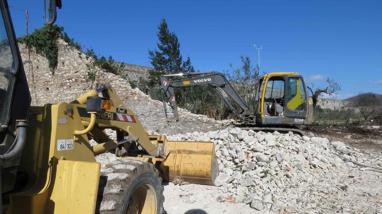 Ruspe in azione per raccogliere le pietre delle mura (foto Batavia)