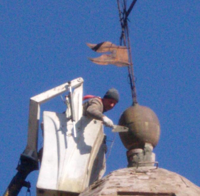 Il vento fa barcollare la croce operai in azione sul campanile