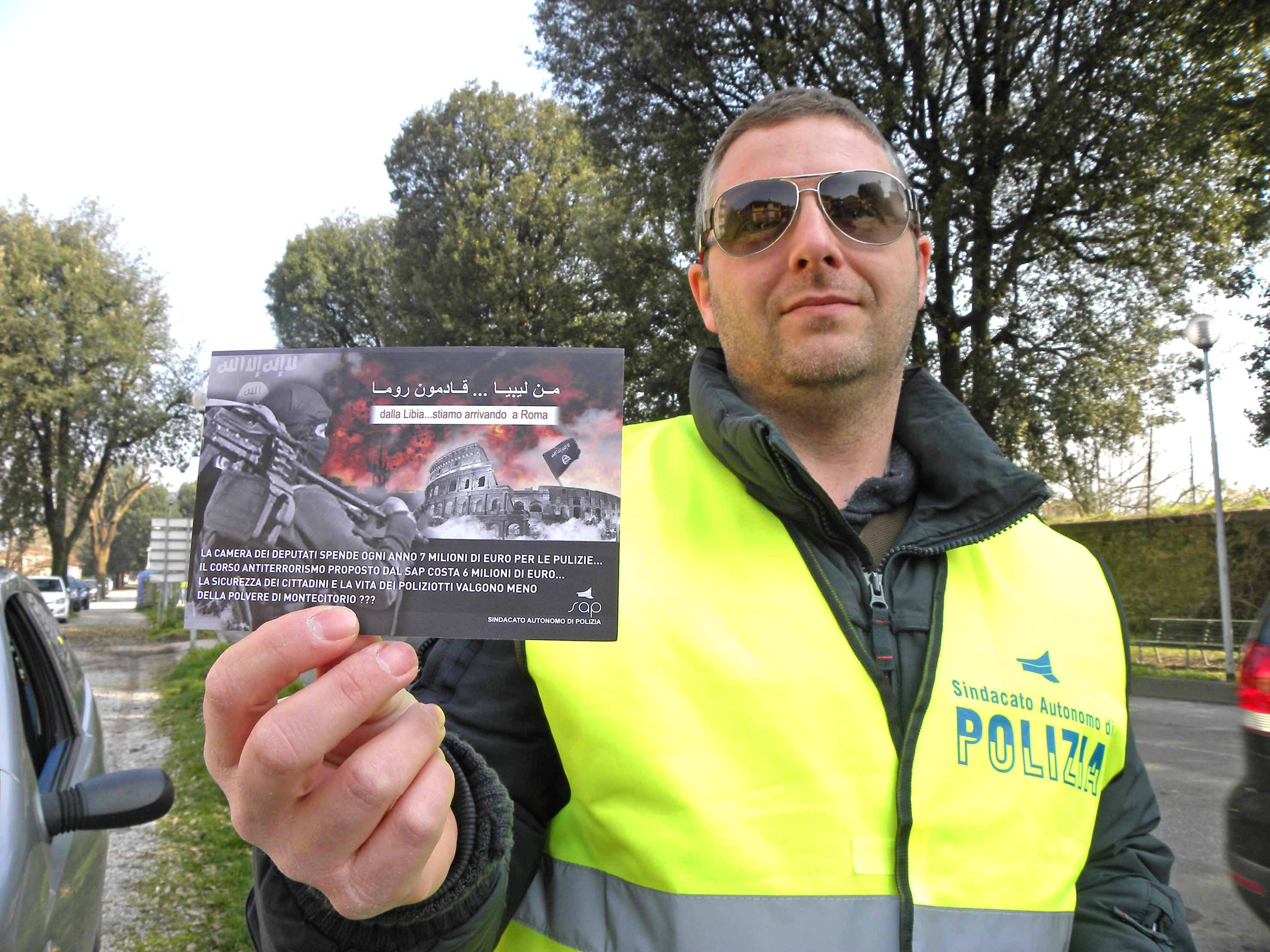 Uno dei poliziotti con la cartolina che viene data agli automobilisti (Foto Gori)