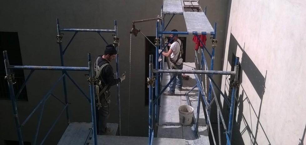 Gli operai in cima all'impalcatura nel cortile del palazzo di giustizia