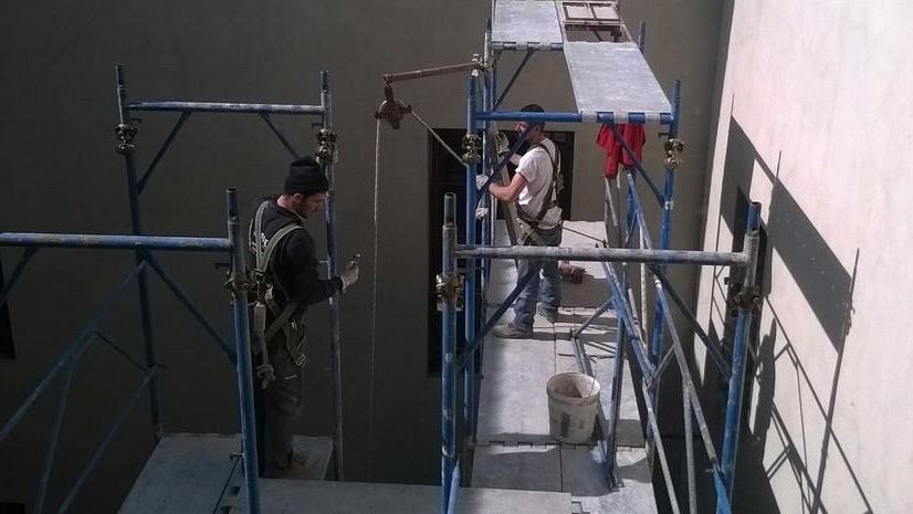 Gli operai in cima all'impalcatura nel cortile del palazzo di giustizia