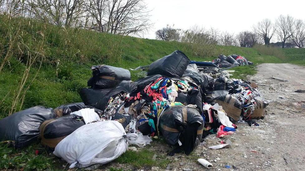 Lungo l’argine una discarica di ritagli delle confezioni