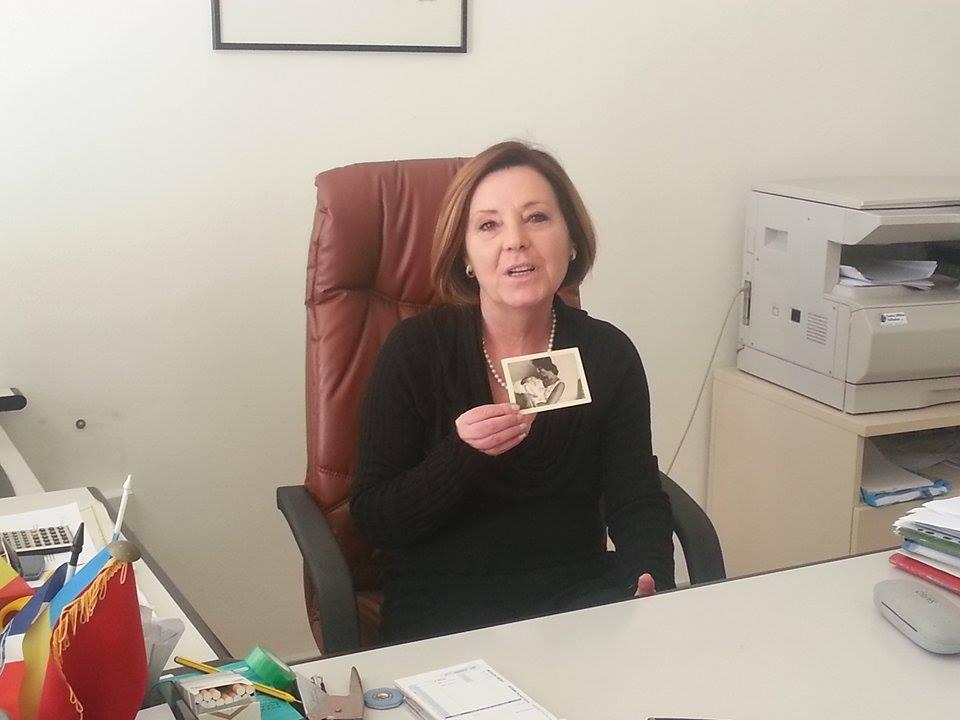 Velia Cristallini, 55 anni, mostra la foto che la ritrae neonata in braccio a una ragazza