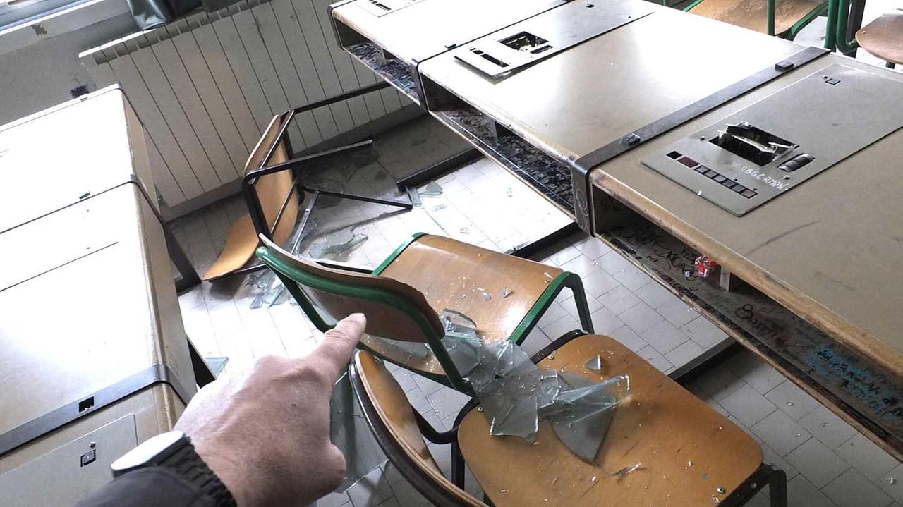 I resti della vetrata su banchi e sedie del laboratorio
