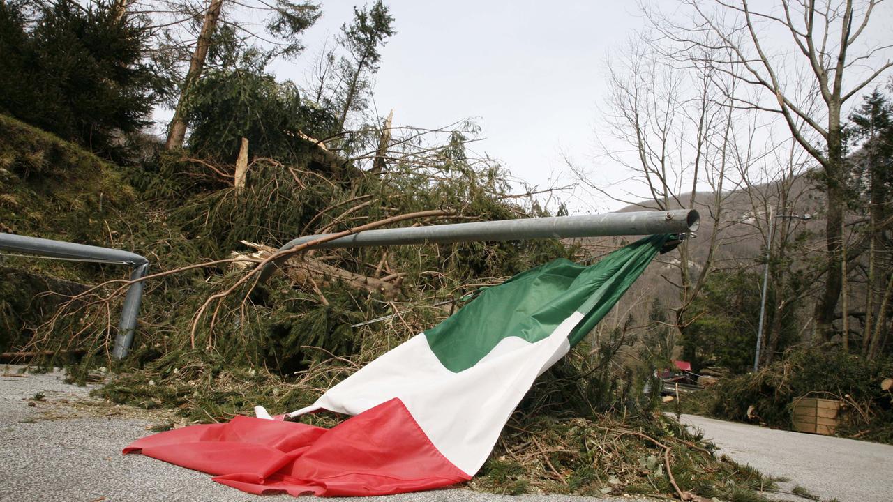 Una bandiera italiana abbattuta lungo il sentiero che porta al Monumento Ossario della strage di Sant'Anna di Stazzema