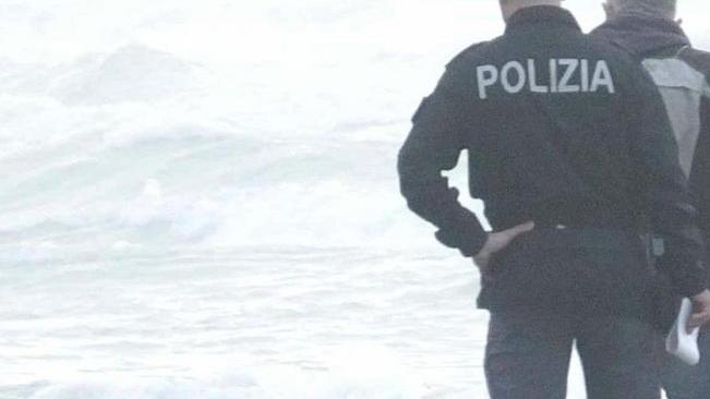 Il mare spinge un corpo sfigurato sulla spiaggia